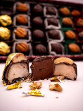 Close-up of assorted chocolates with a box of chocolates in the background.