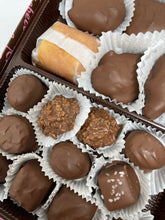 A box of assorted milk chocolates, including caramels, toffees, and various other chocolate candies.