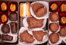 Assorted chocolates including pecans and truffles in a box.