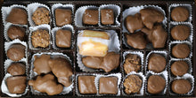 A box of assorted milk chocolates including caramels, toffees, and various other chocolate candies.