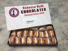 A box of Rebecca Ruth chocolates with individually wrapped puffamels displayed inside. The packaging has the brand's logo and the text 'Famous Since 1919'.